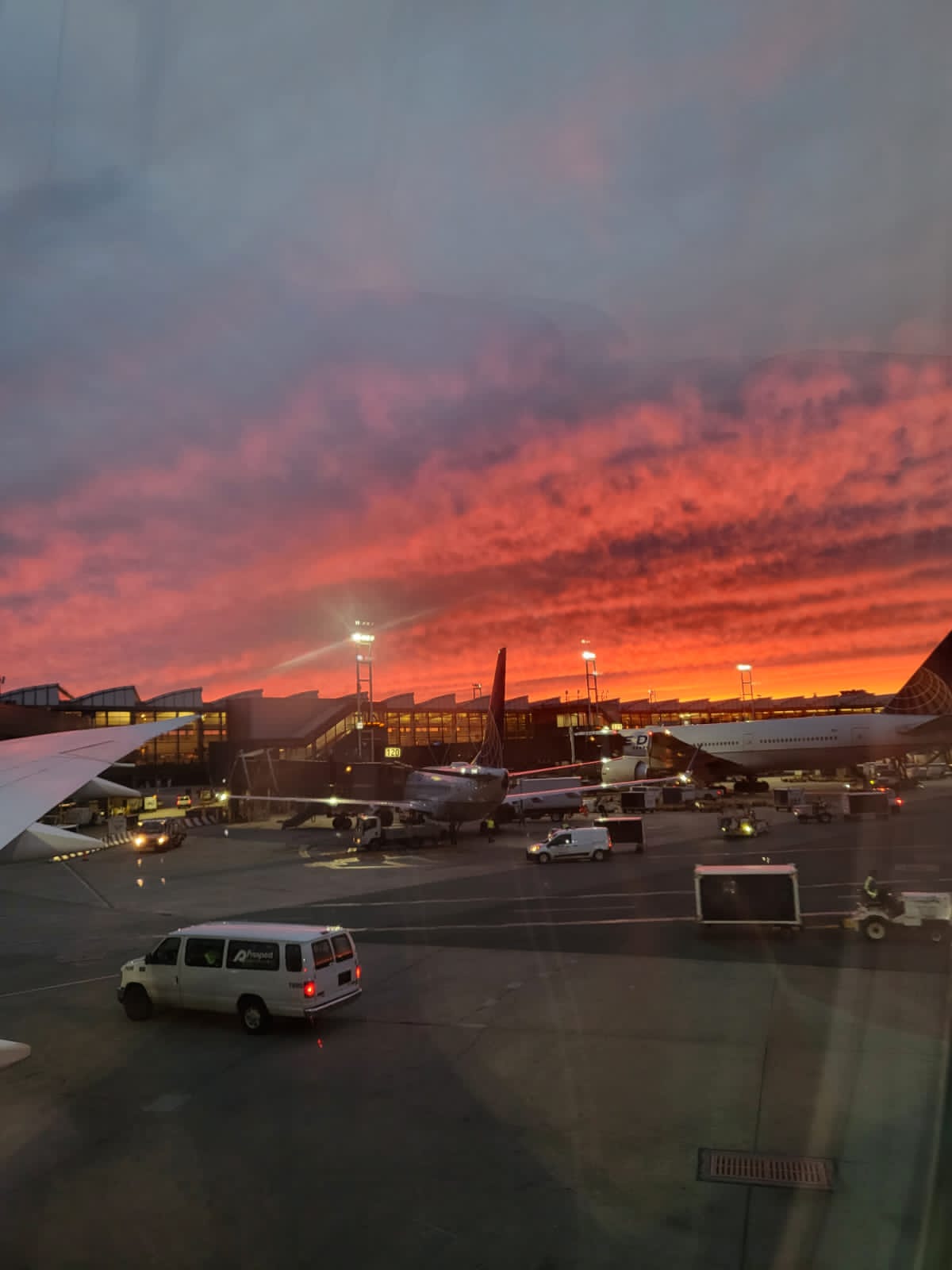 Terminal aeroportuaria al atardecer, con un avión en plataforma
